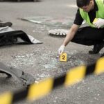 Forensic investigator marking evidence at crash scene