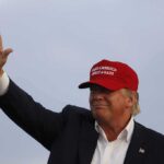 Swing Seats Panic As Trump Takes Center Donald Trump waving in a red cap