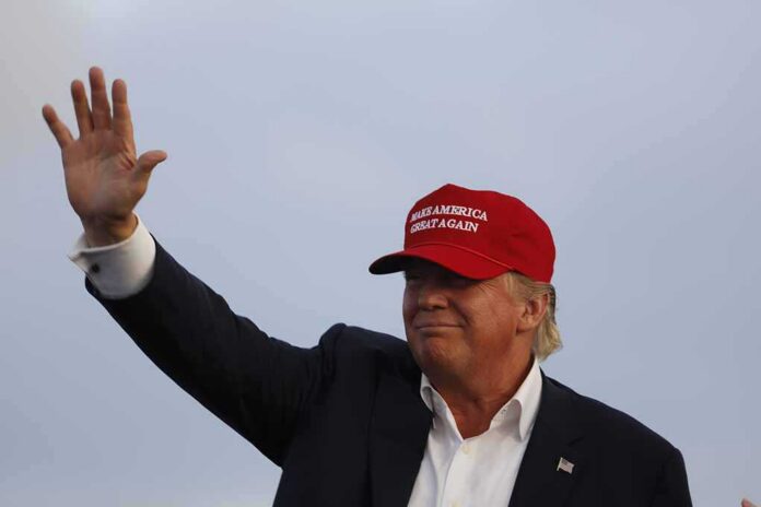 Donald Trump waving in a red cap
