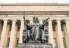 Alma Mater statue before a neoclassical library facade