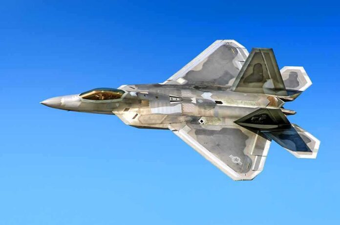 shutterstock_514318066 Stealth fighter jet in flight against a clear blue sky