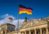 Chancellor Friedrich Merz Cornered – AfD Roars Ahead German flag flying above the Reichstag building