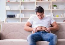 Men Pregnant? Planned Parenthood’s Claim Ignites Backlash Manny MUA sitting on a couch pinching his belly