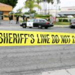 In-N-Out Bloodbath: Shooter Down, Mystery Deepens yellow sheriff's line tape blocks a street near police cars