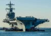Eisenhower Scare: Deck Disaster Sparks Navy Probe Aircraft carrier guided by tugboats in a harbor