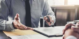 Business meeting with two people reviewing a document on a clipboard