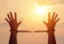 Knife-To-Throat Monster Up For Parole raised hands breaking chains against a sunset sky