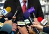 Ethics Firestorm Engulfs Federal Judges Press microphones surround a suited spokesperson