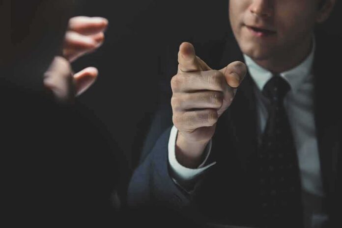 Man in suit pointing a finger during a tense conversation