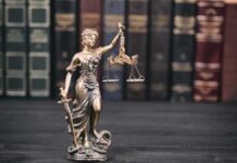 Life-Insurance Kill? Clemency Shot Down Lady Justice statue with scales in front of law books