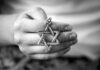 Antisemitism Allegation Ignites France Hand holding a Star of David pendant