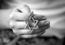 Antisemitism Allegation Ignites France Hand holding a Star of David pendant