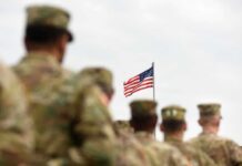 Rio Grande Shootout Triggers Troop Surge U.S. flag flying above a formation of soldiers in uniform