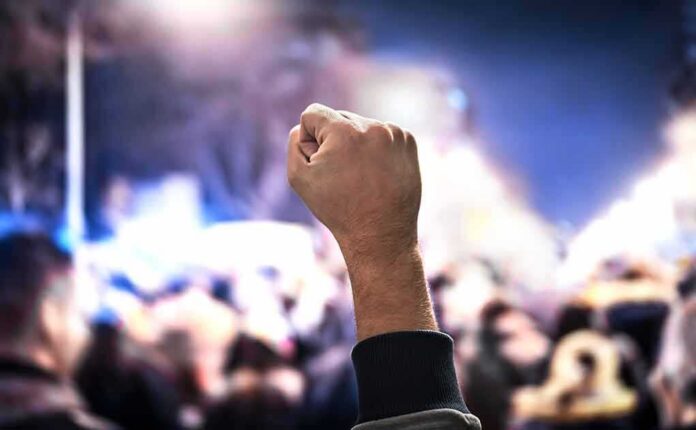 Raised fist at a nighttime crowd