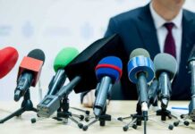 FBI-Level Alarm – Torture Threats Flood Lawmakers microphones clustered on a table at a press conference
