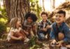 Group of children laughing together in a sunny forest