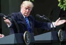 Donald Trump speaking at dual podiums with arms outstretched