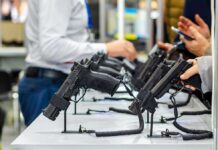 Gun Rights SURGE: Interstate Wall Falls Handguns displayed on stands at a trade show counter