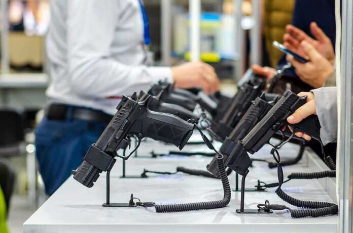 Handguns displayed on stands at a trade show counter