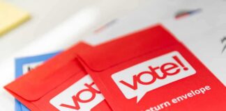 Red vote return envelopes on a table