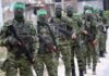 Armed men in camouflage uniforms standing in a line