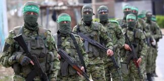 Armed men in camouflage uniforms standing in a line