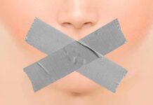 Close-up face with mouth covered by crossed duct tape