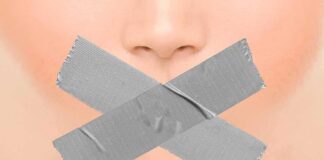 Close-up face with mouth covered by crossed duct tape