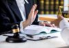 Lawyer refusing envelope during meeting at desk