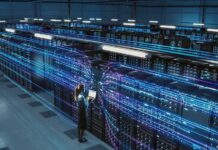 Technician with laptop in a large data center aisle