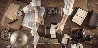 Accountant using vintage adding machine with paper tape
