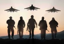 Soldiers walking with fighter jets flying overhead at sunset
