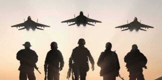 Soldiers walking with fighter jets flying overhead at sunset