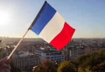 France IGNITES: Looters Run Wild French flag waving over a city skyline at sunset