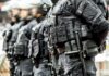 Riot police officers in tactical gear standing in a line