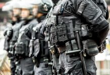 Riot police officers in tactical gear standing in a line
