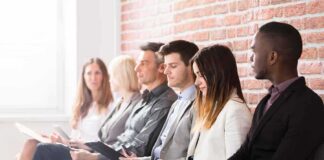 Job applicants seated in a row with clipboards