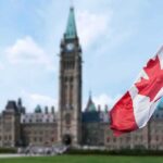 Neutrality Or Erasure? Prayer Purge Roils Canada’s Ranks Canadian flag with Parliament building in background